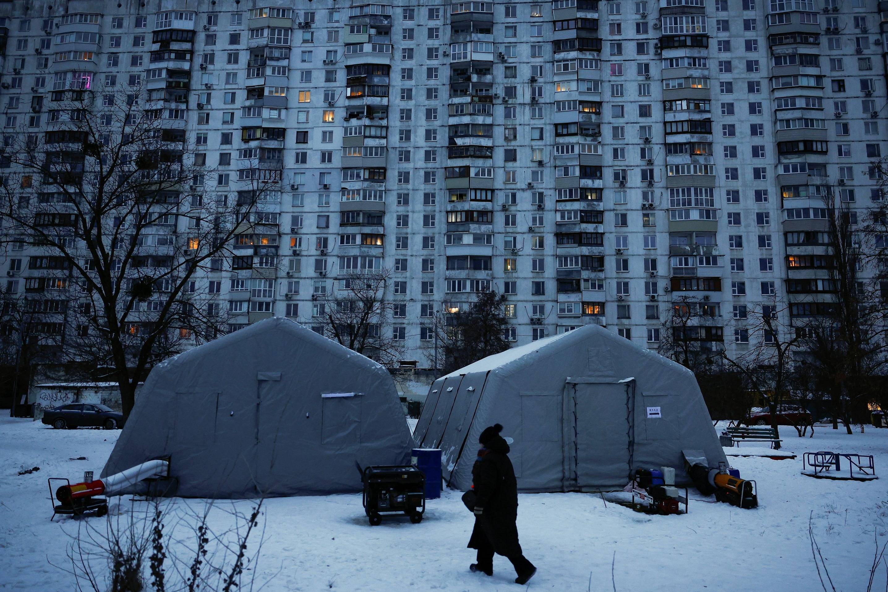 Pessoa caminha perto de centro montado pelo governo da Ucrânia em Kiev para fornecer aquecimento e serviços básicos em meio à guerra com a Rússia (REUTERS/Alina Smutko)