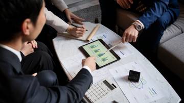 Empresários que trabalham com ipad de alto ângulo