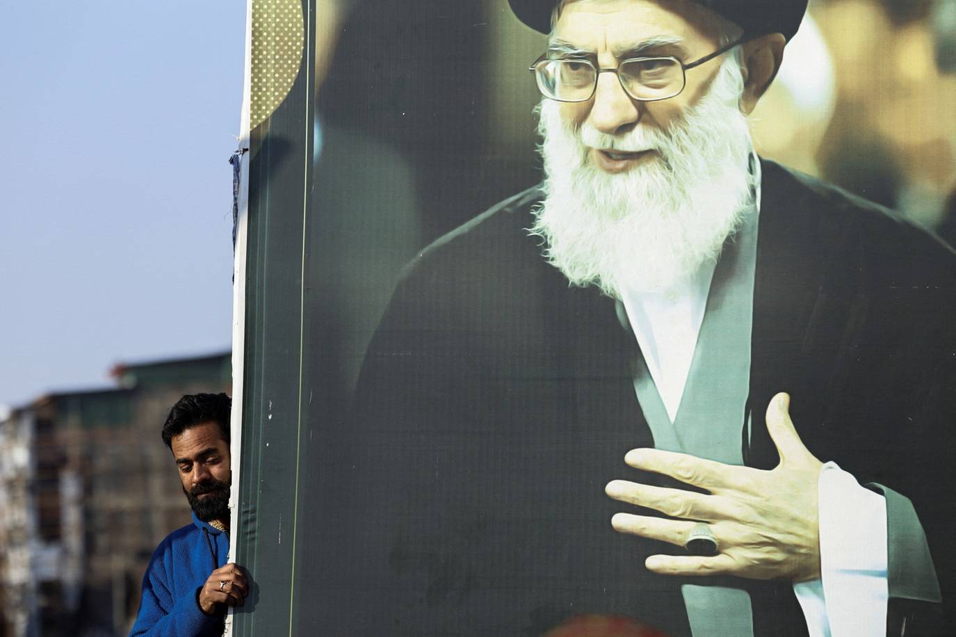 Um homem segura a foto do líder supremo do Irã, aiatolá Ali Khamenei, enquanto muçulmanos xiitas participam de uma marcha de protesto após Khamenei ter sido morto em ataques israelenses e norte‑americanos no sábado, em Srinagar, na Caxemira indiana, em 1º de março de 2026. REUTERS/Sharafat Ali TPX IMAGES OF THE DAY