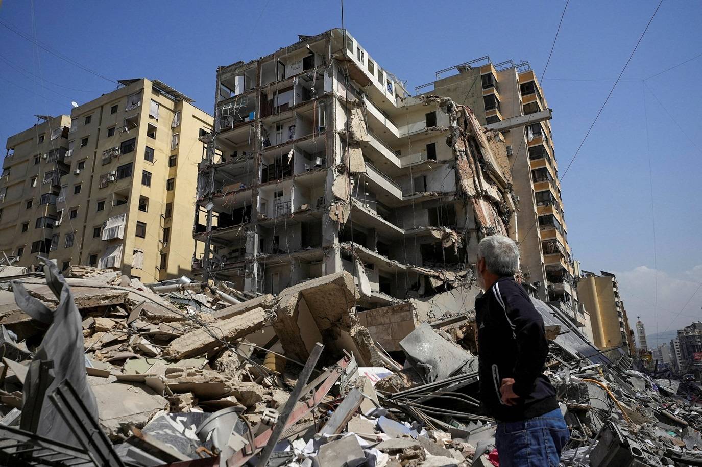 Homem observa prédio danificado após ataques israelenses em Beirute
12 de março de 2026. REUTERS/Stringer/Foto de arquivo
