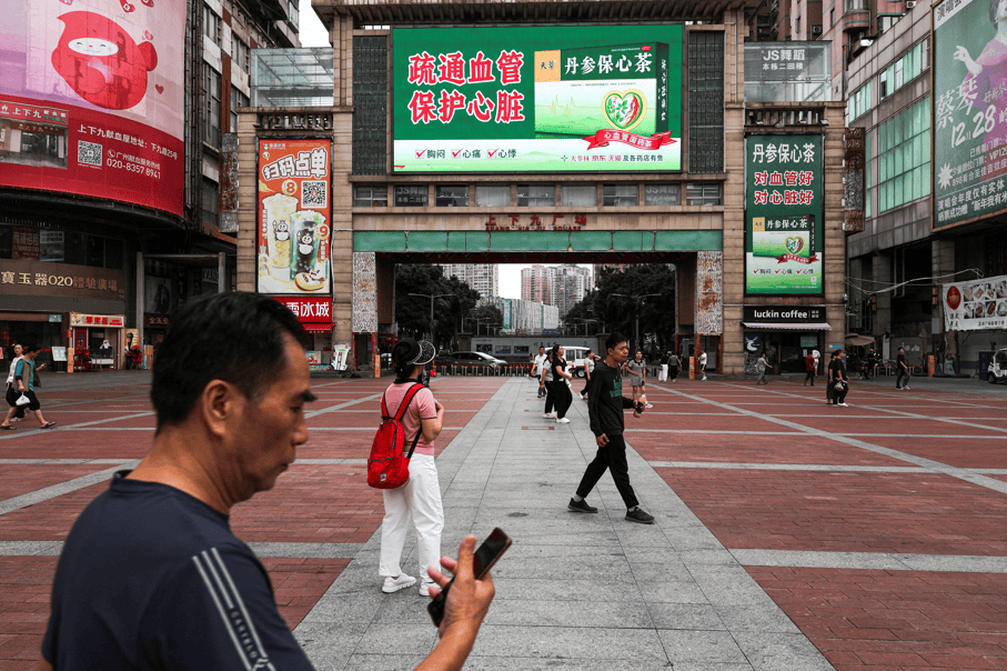Pessoas caminham em uma praça em Guangzhou, China 15 de abril de 2026