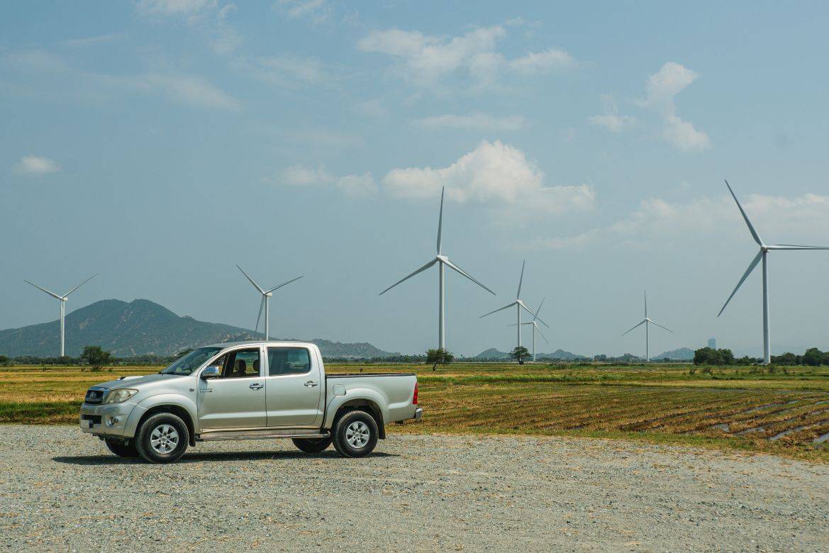 Veículo elétrico e turbinas eólicas ao fundo