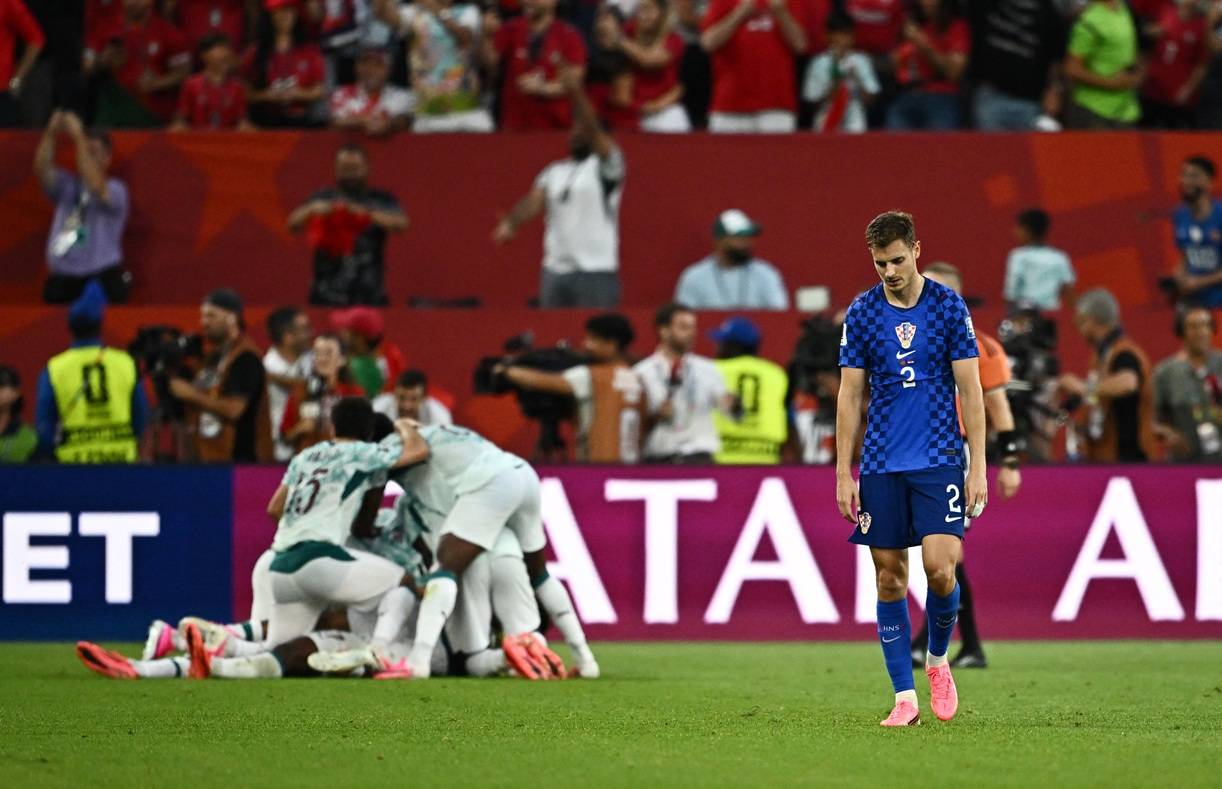 2 de julho de 2026 - Josip Stanisic, da Croácia, lamenta enquanto jogadores portugueses comemoram o segundo gol. Foto: REUTERS/Dylan Martinez