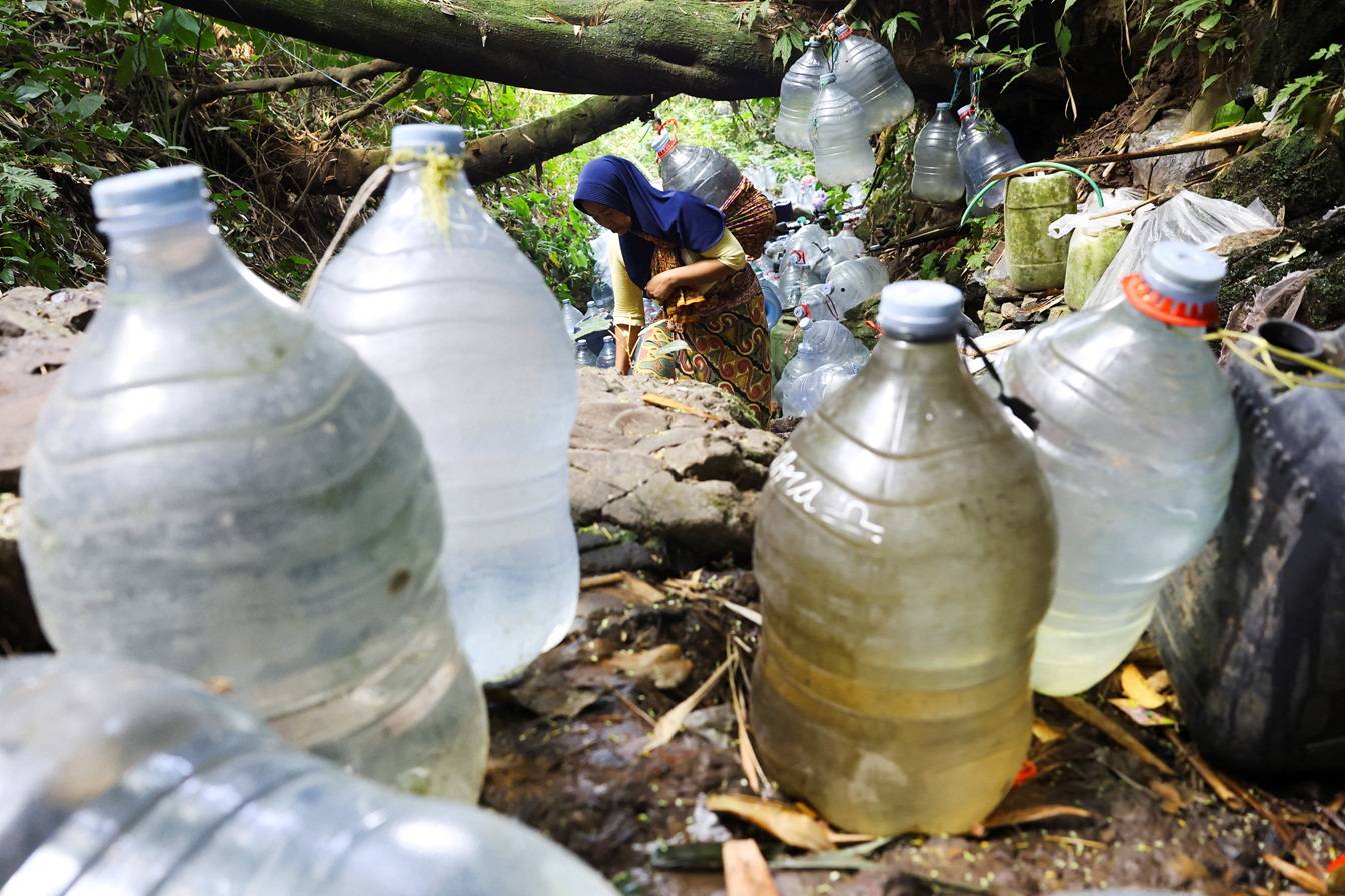 Uma moradora coleta água de nascente em uma área afetada pela seca durante a estação seca, em meio a previsões de que o El Niño pode contribuir para condições mais secas do que o normal, na vila de Gunung Batur, Cilegon, província de Banten, Indonésia, 17 de julho de 2026. REUTERS/Ajeng Dinar Ulfiana