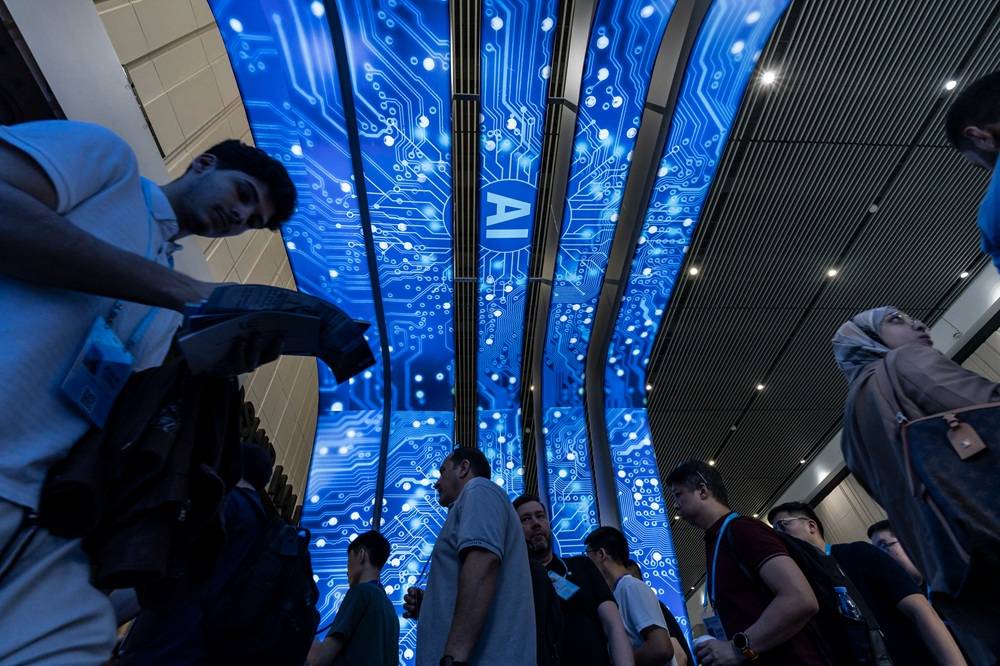 Participantes passam por sinalização sobre inteligência artificial na Feira de Cantão, em Guangzhou, em abril.

Fotógrafo: Qilai Shen/Bloomberg